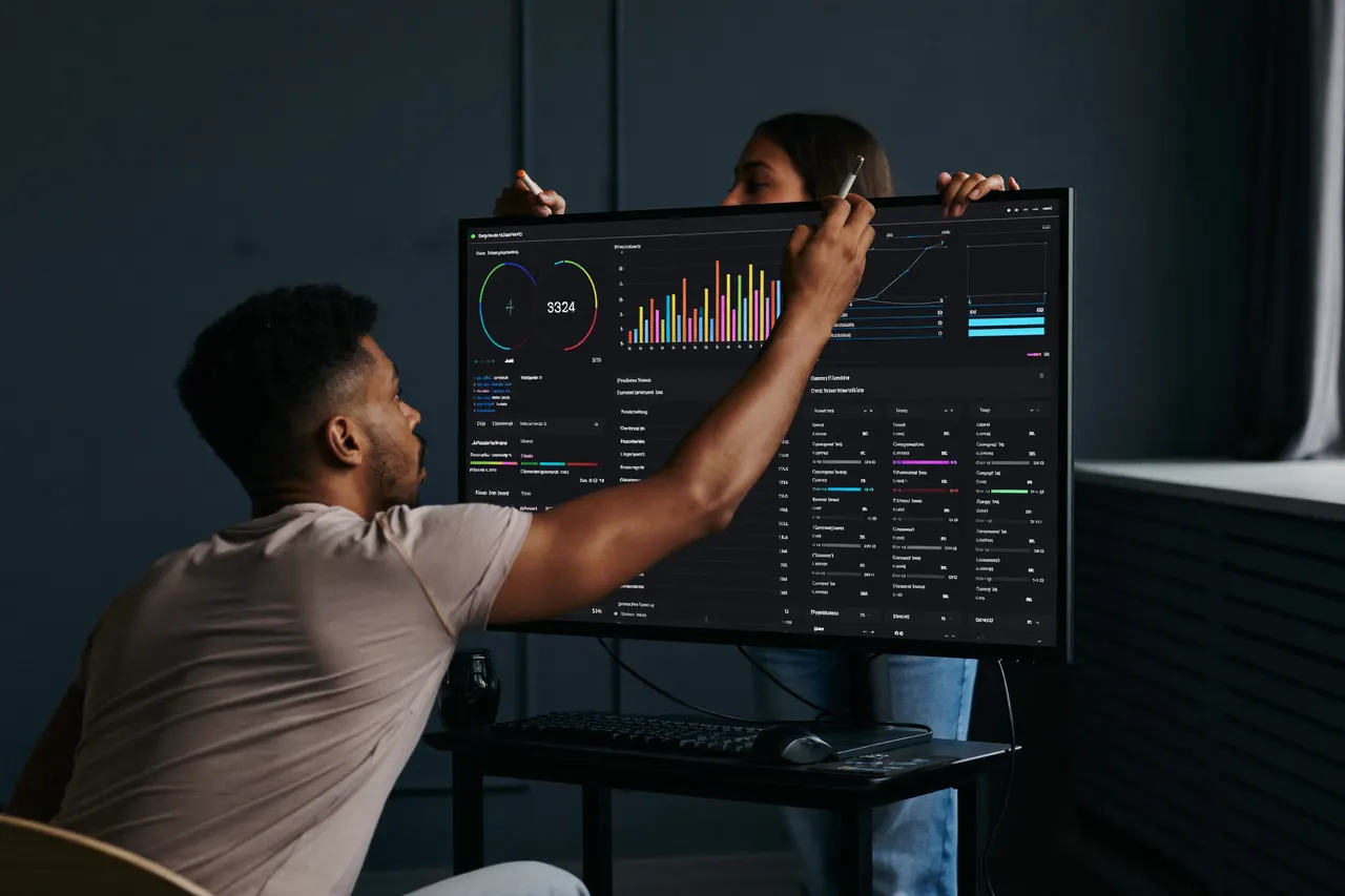 Two colleagues reviewing an analytics dashboard in a modern agency studio