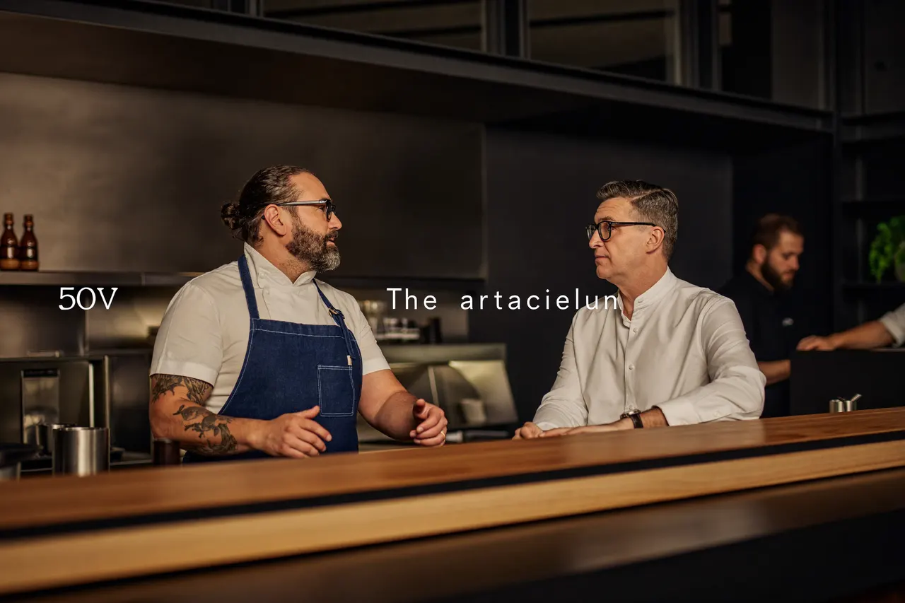 Chef and front of house manager talking at the pass of a modern restaurant